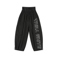 Black pants with 'CHILL WHITE' text on a white background