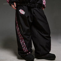 Black pants with pink and white design on a gray background