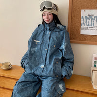 Person wearing a blue denim outfit with a matching jacket and pants, sitting on a wooden surface.