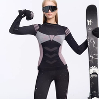 Person wearing a black and gray ski suit with goggles and gloves, holding a ski.