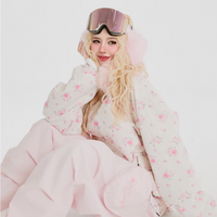Person wearing a pink skiing jacke with goggles on a white background