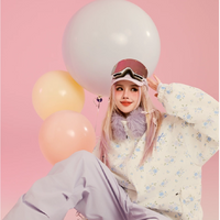 Person in stylish outfit with balloons on a pink background, featuring Swego brand autumn winter collection.
