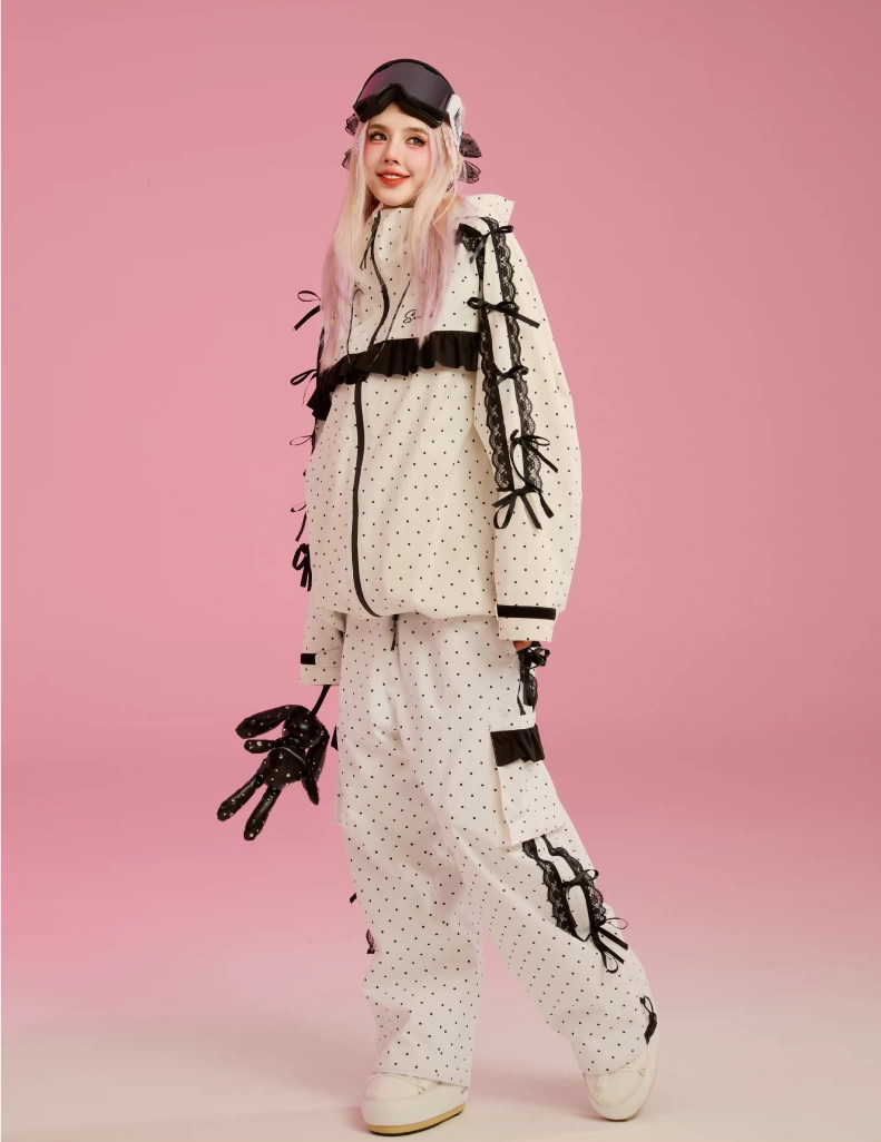 Person wearing a stylish winter outfit with polka dot pattern on a pink background