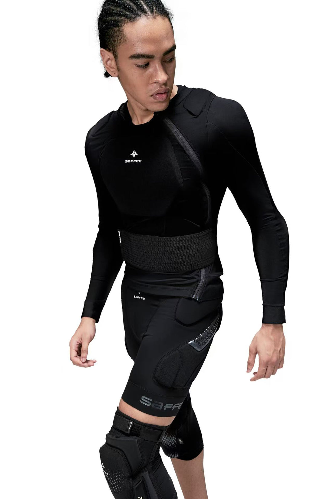 Person wearing a black  protective body armor with visible branding on a white background