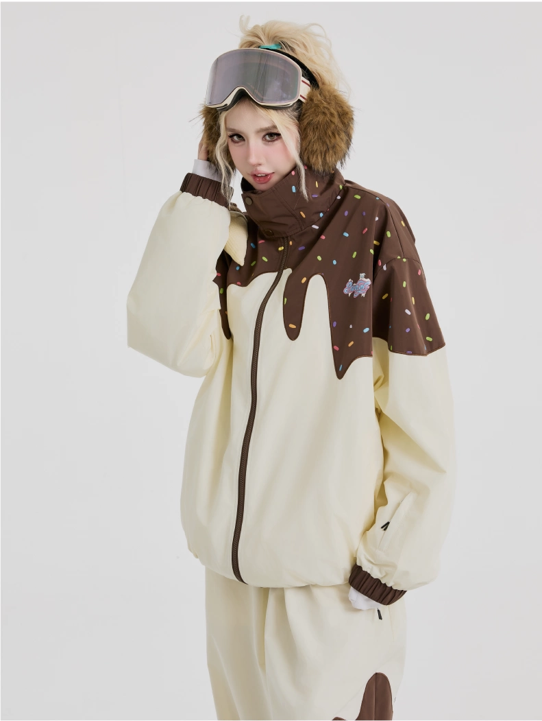 Person wearing a cream-colored onesie with brown accents and goggles on a white background