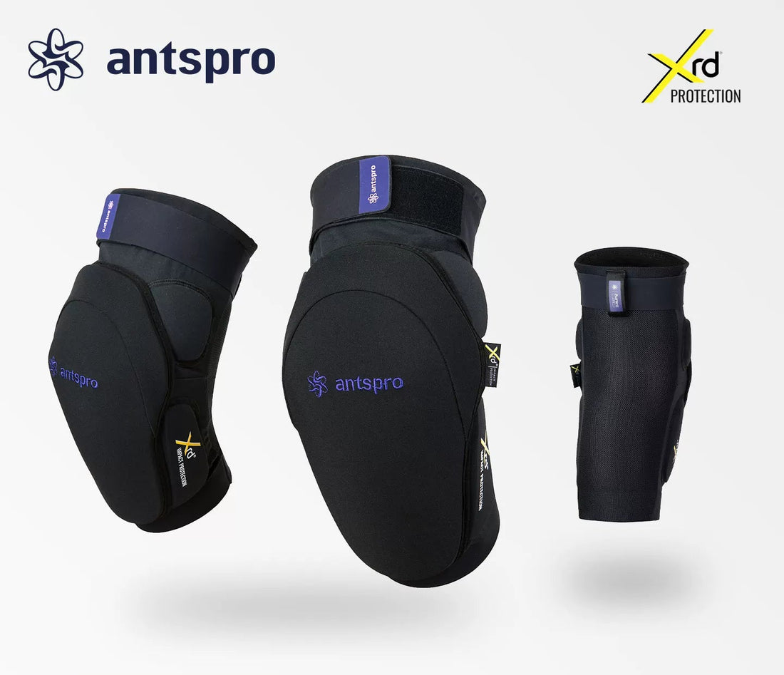 Three views of black Antspro knee and elbow protection gear with purple branding and a yellow XRD logo, shown on a light gray background with Antspro branding and a Japanese text banner at the bottom.