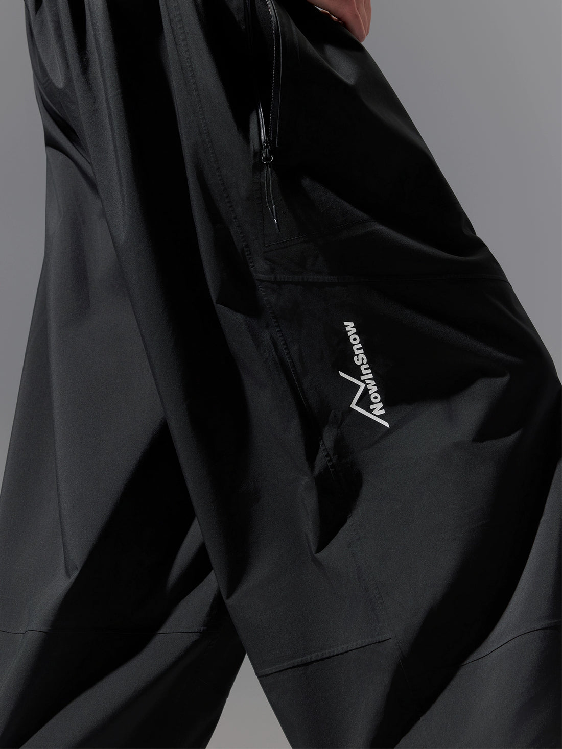 Black snow pants with a brand logo on a gray background