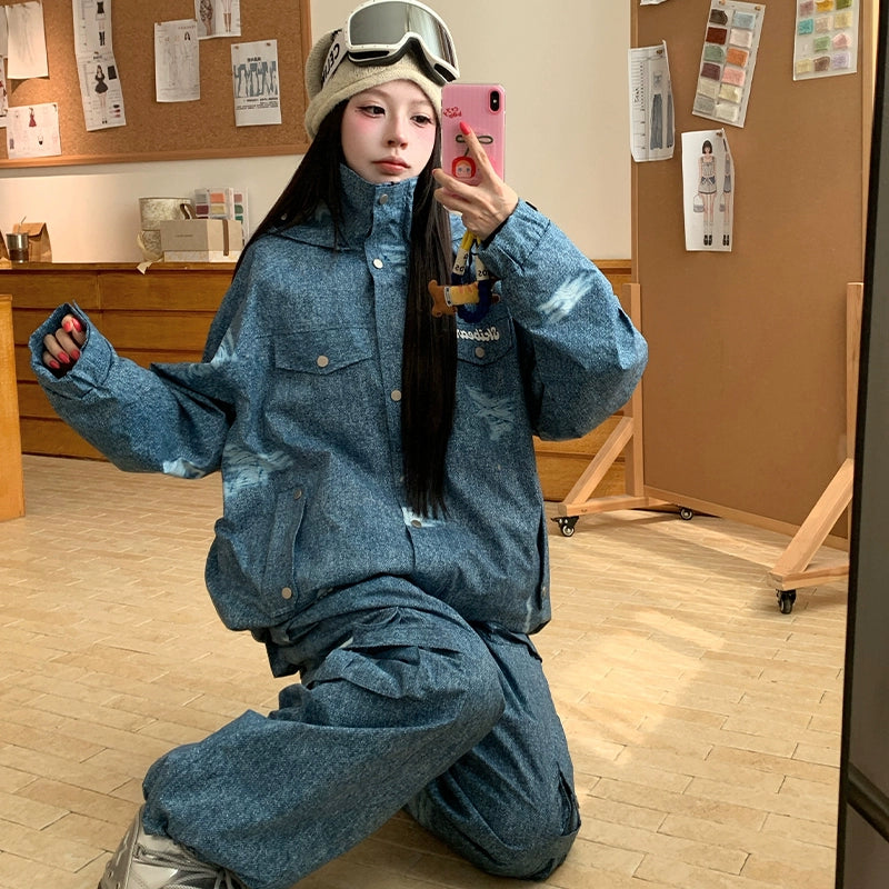 Person wearing a blue denim outfit taking a mirror selfie in an indoor setting.