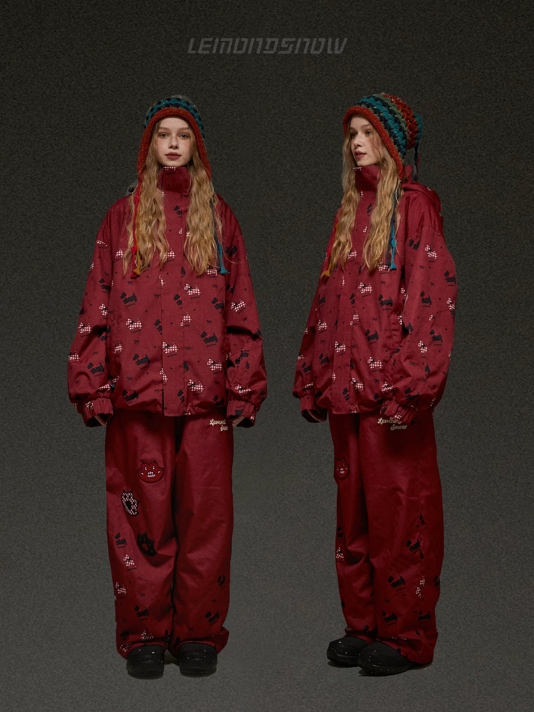 Red snowsuit with pattern worn by a person on a dark background, featuring the brand &
