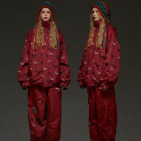 Red snowsuit with pattern worn by a person on a dark background, featuring the brand 'LEINDAISNOW'.