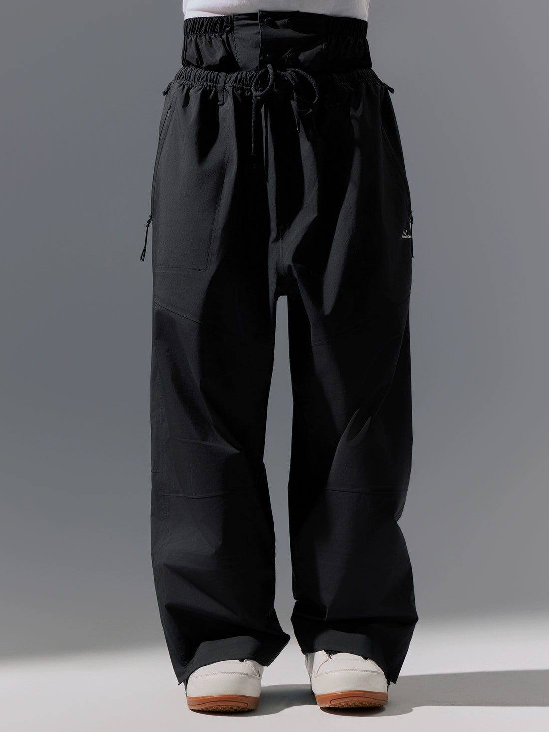 Black pants worn by a person on a gray background