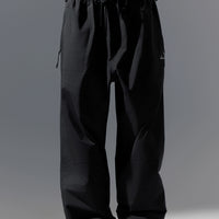 Black pants worn by a person on a gray background