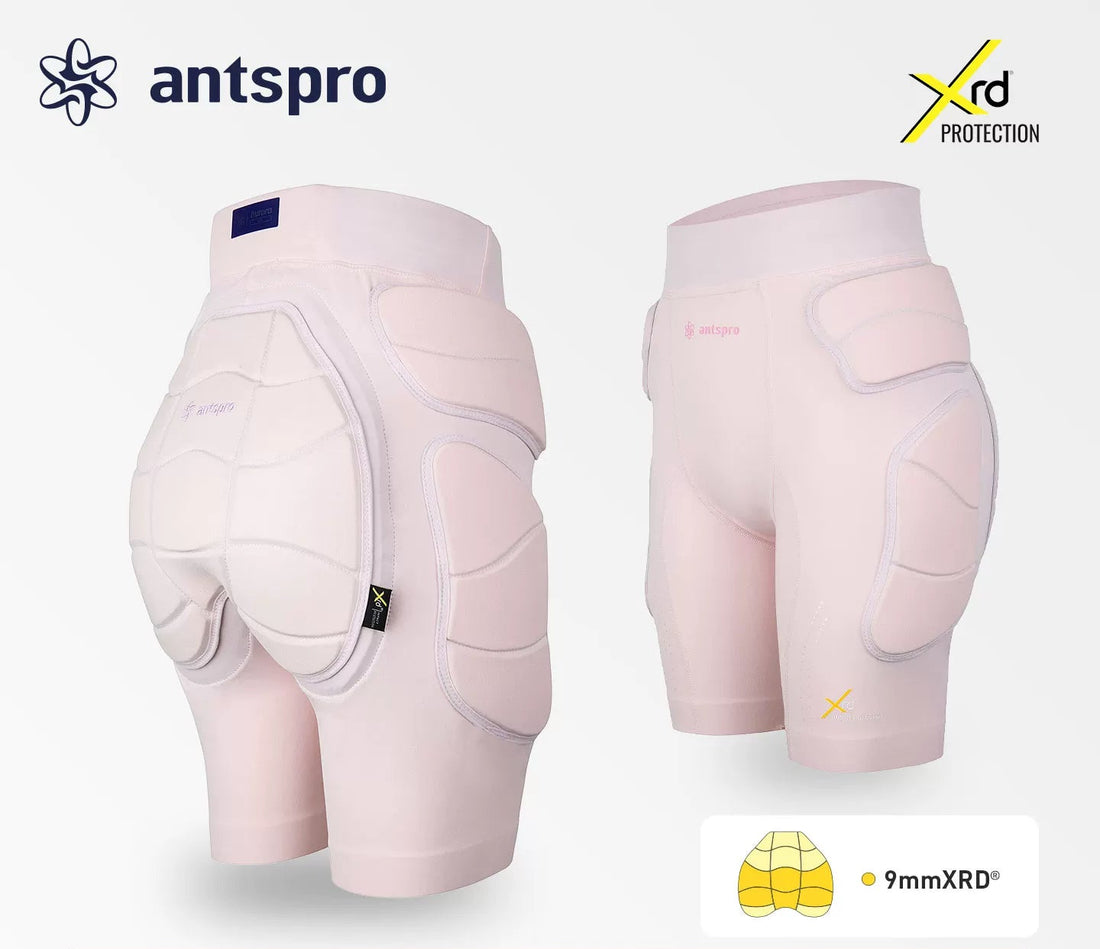 Antspro 9mm XRD protective shin and thigh guards shown from both front and back views on a light gray background, featuring a white and pale pink color scheme with technical specifications and brand logos.