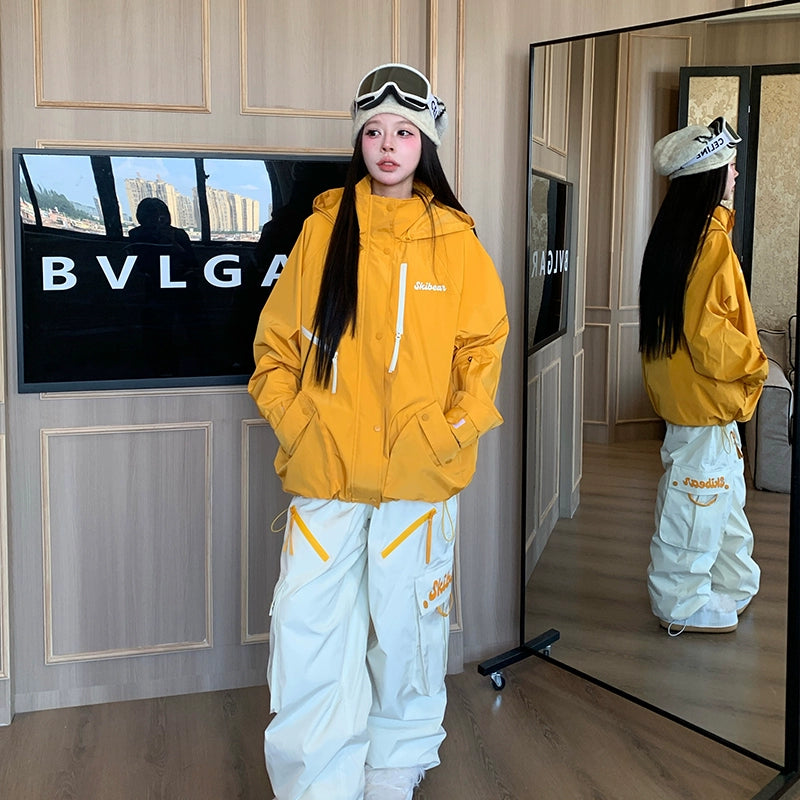 Person wearing a yellow jacket and white pants standing in front of a mirror.