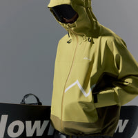 Person wearing a green jacket with a brand logo, holding a black snowboard with white text.