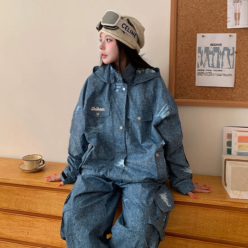 Person wearing a blue denim outfit sitting on a wooden surface with a bulletin board in the background.