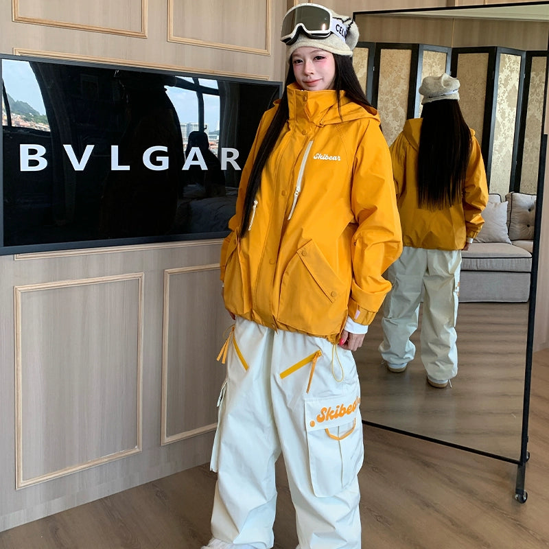 Person wearing a yellow jacket and white pants with 'Skiboutique' branding, standing in front of a BVLGARI display.