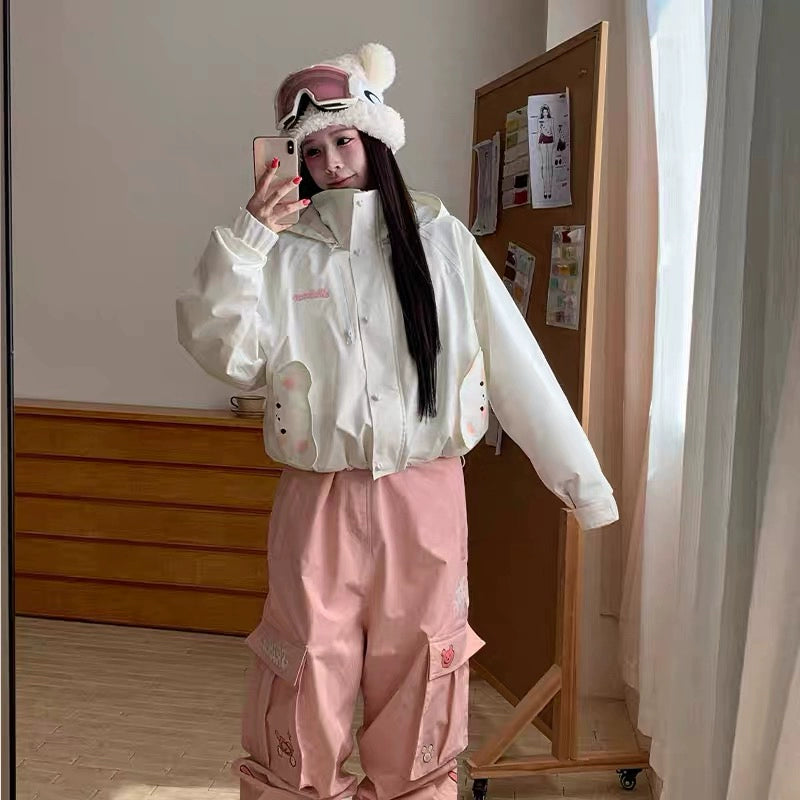 Person wearing a white jacket and pink pants taking a mirror selfie.