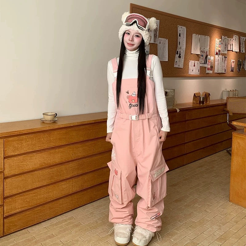 Person wearing a pink snowsuit with cartoon characters in a room with wooden furniture.