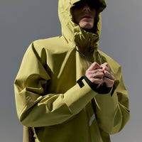Person wearing a yellow raincoat against a gray background