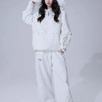 A woman wearing a white skiing suit with a star pattern and a fur hood.