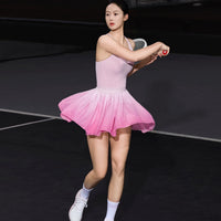 Woman in a pink dress playing tennis on a court