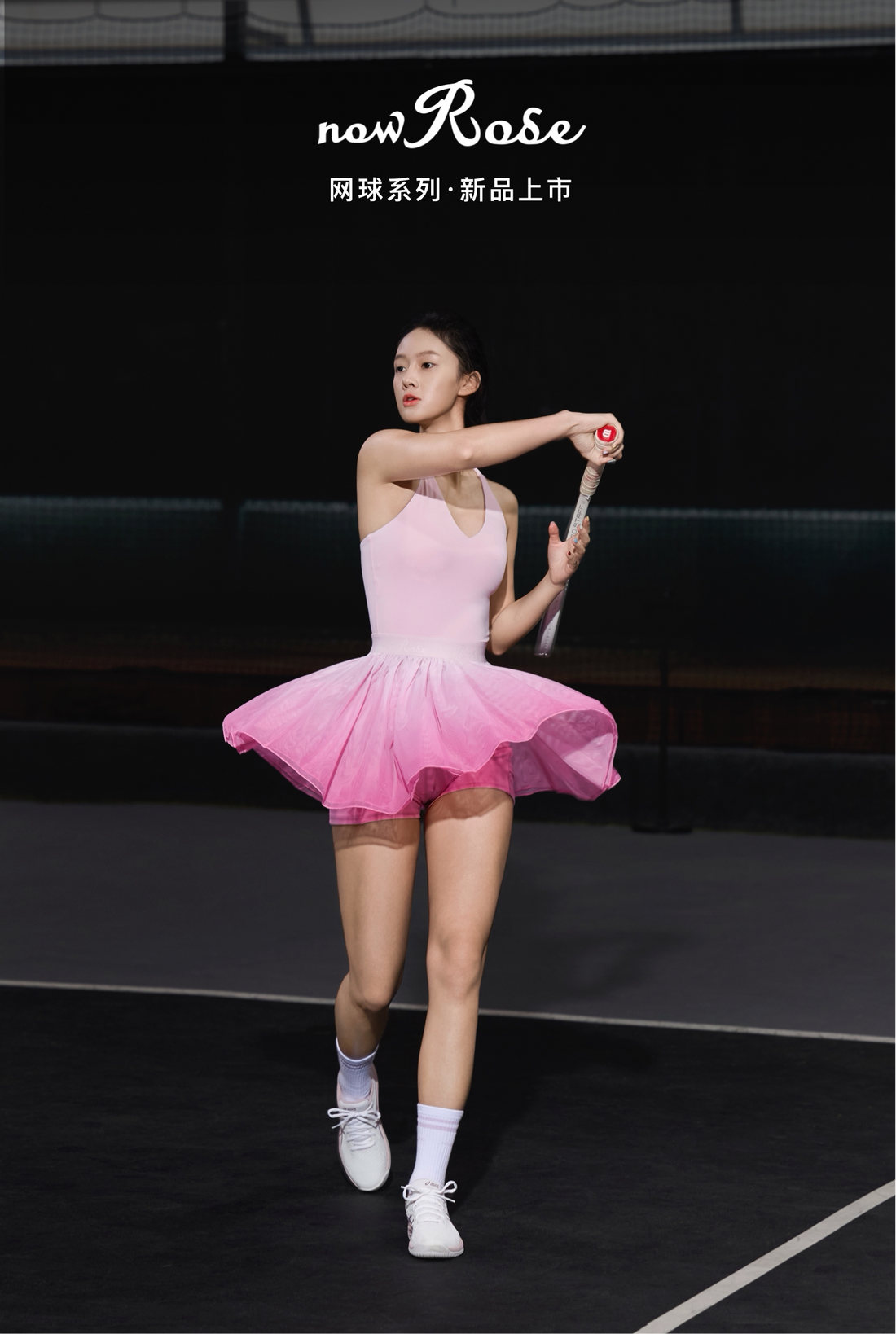 Woman in a pink tennis dress holding a tennis racket on a tennis court with &
