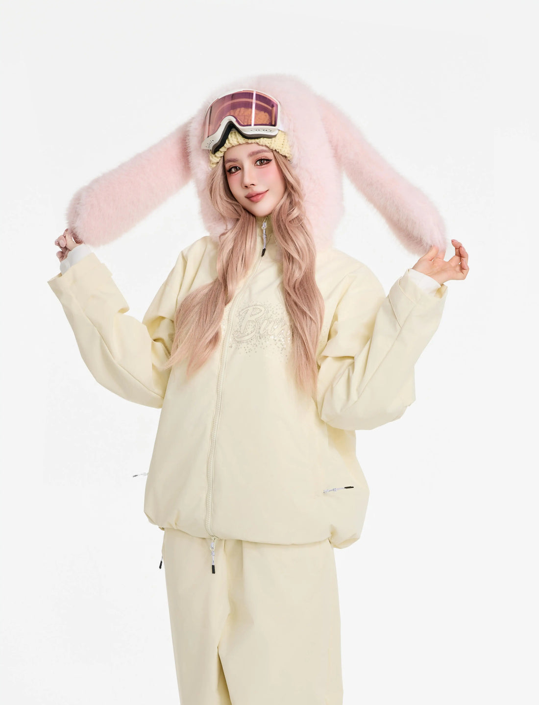 Person wearing a light-colored outfit with pink bunny ears on a white background