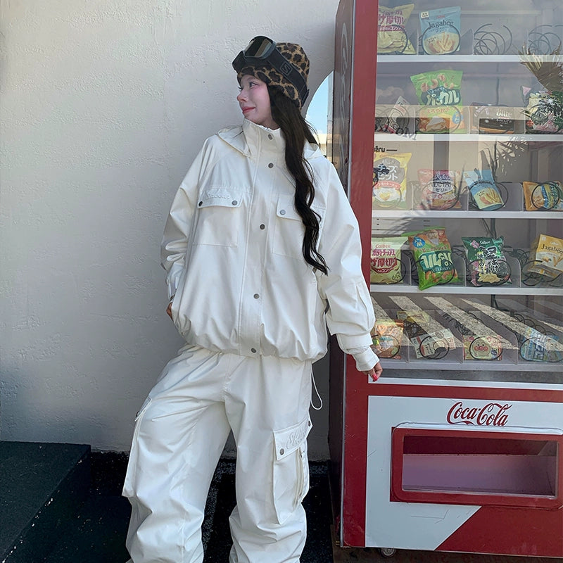 Person in a white skiing outfit standing next to a Coca-Cola vending machine.