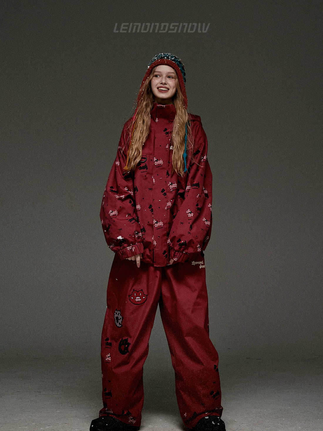 Person wearing a red snowsuit with patterns on a gray background