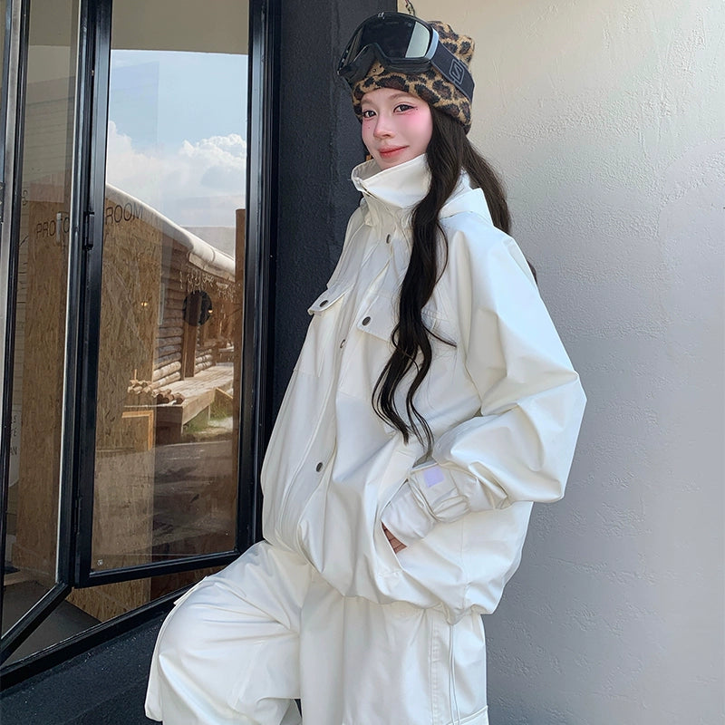 Person wearing a white skiing snowsuit and leopard print helmet with goggles indoors.
