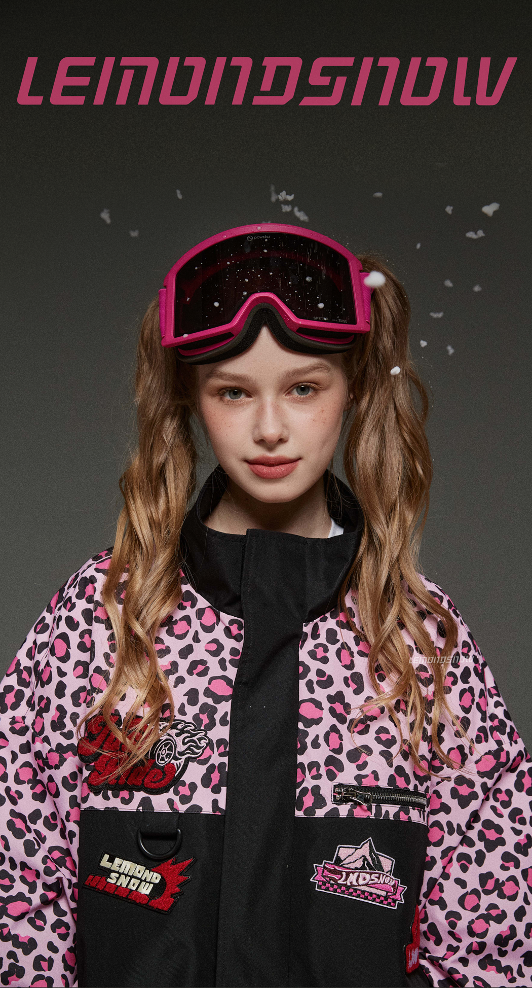 Person wearing a leopard print jacket with pink accents and goggles, with 'LEMONSNOOW' branding.