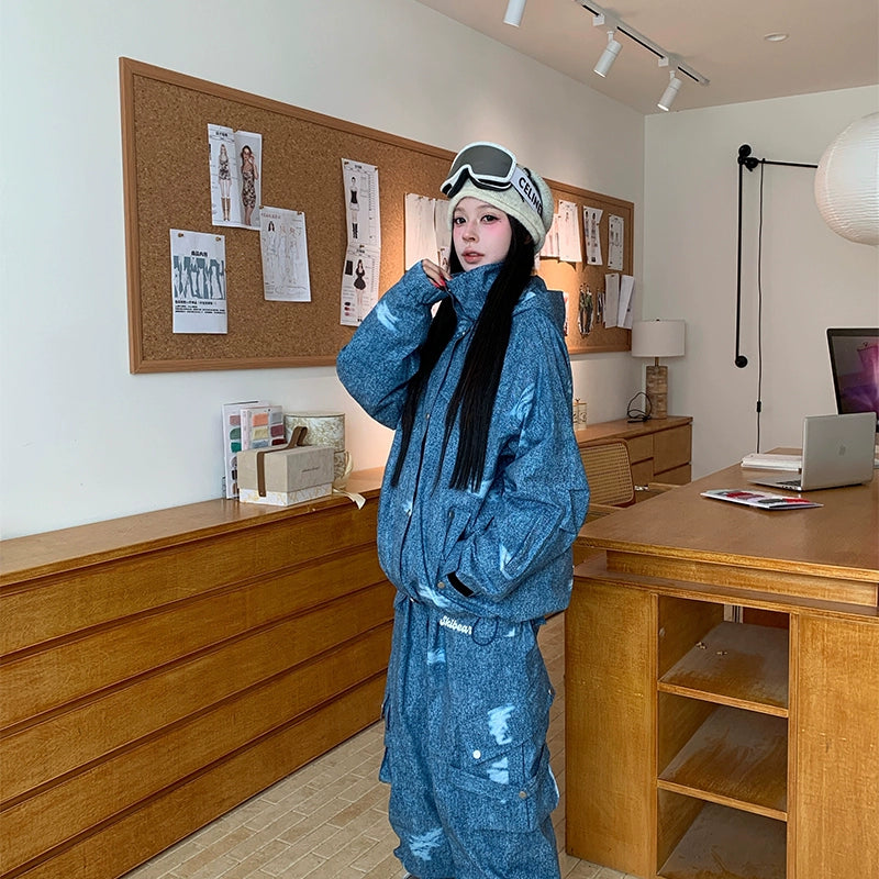 Person wearing a blue tracksuit with goggles on their head in an office setting