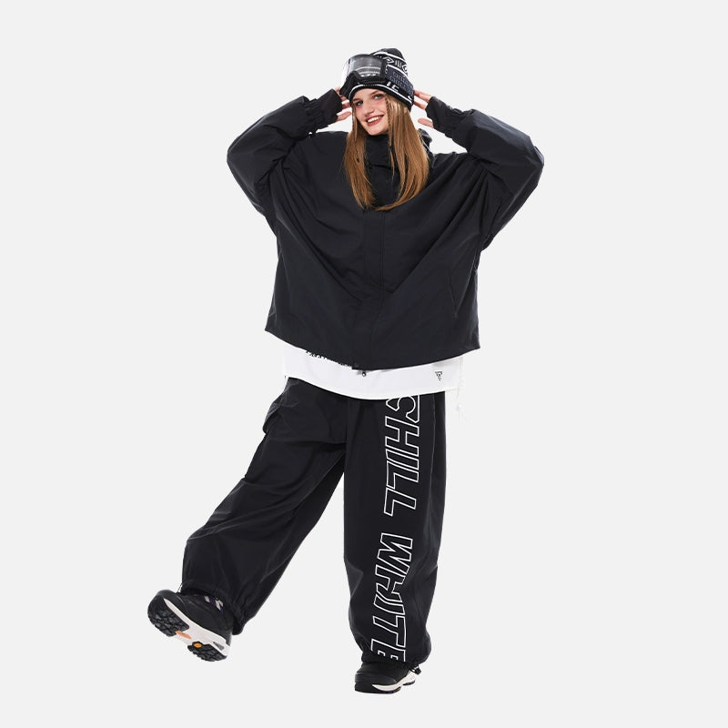 Person wearing a black skiing outfit with 'CHILL WIFE' text on pants against a white background