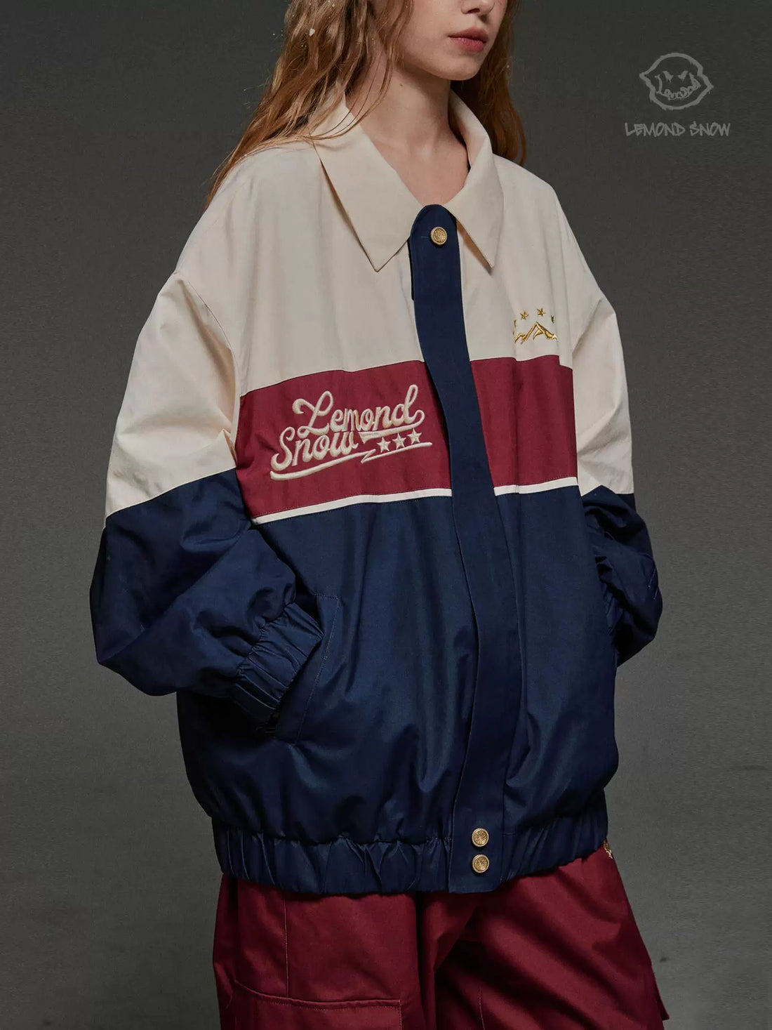 Person wearing a two-tone jacket with 'Lemond Show' branding on a gray background