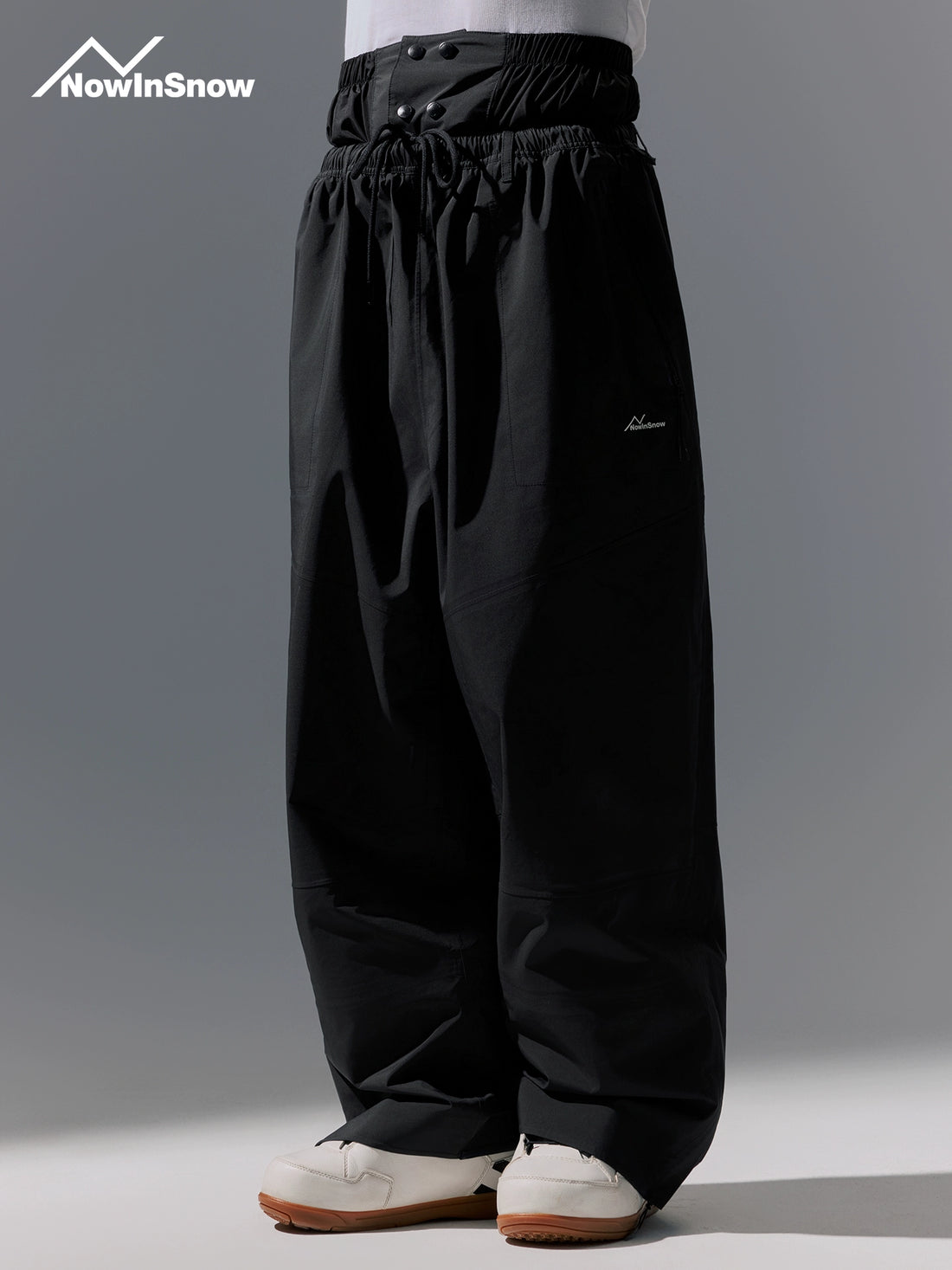 Black pants with a brand logo on a gray background