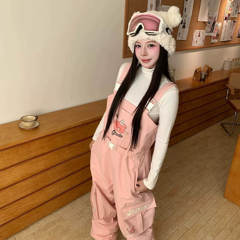 Person wearing a pink snowsuit and helmet with goggles indoors.