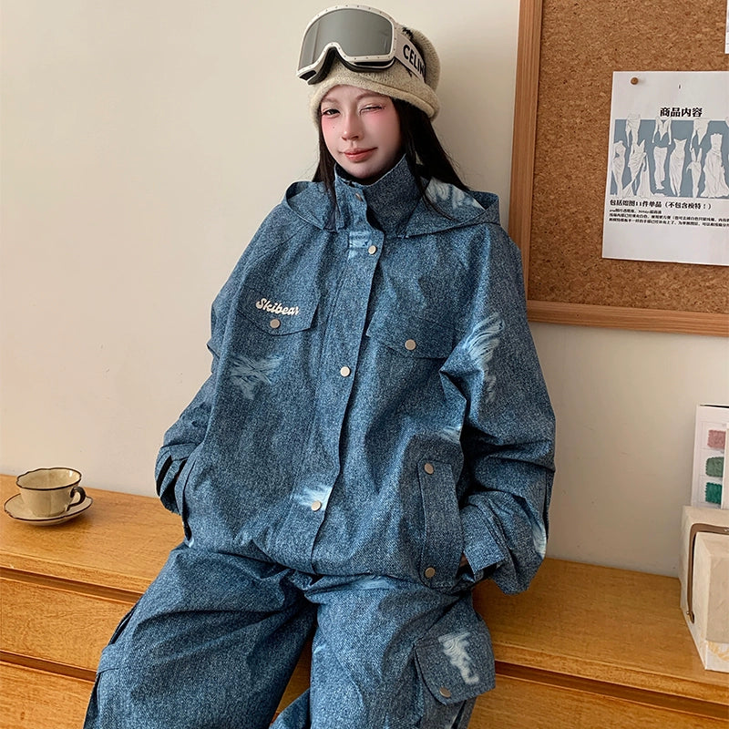 Person wearing a blue denim outfit with a matching jacket and pants, sitting on a wooden surface.