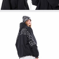Person wearing a black outfit with text design, posing against a white background.