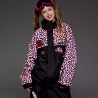 Child wearing a leopard print jacket and black pants with goggles on a gray background