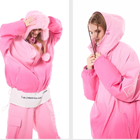Person wearing a pink onesie with a hood and text on a white background